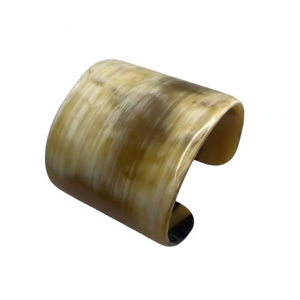Wide polished buffalo horn cuff with cream and brown streaks on a white background