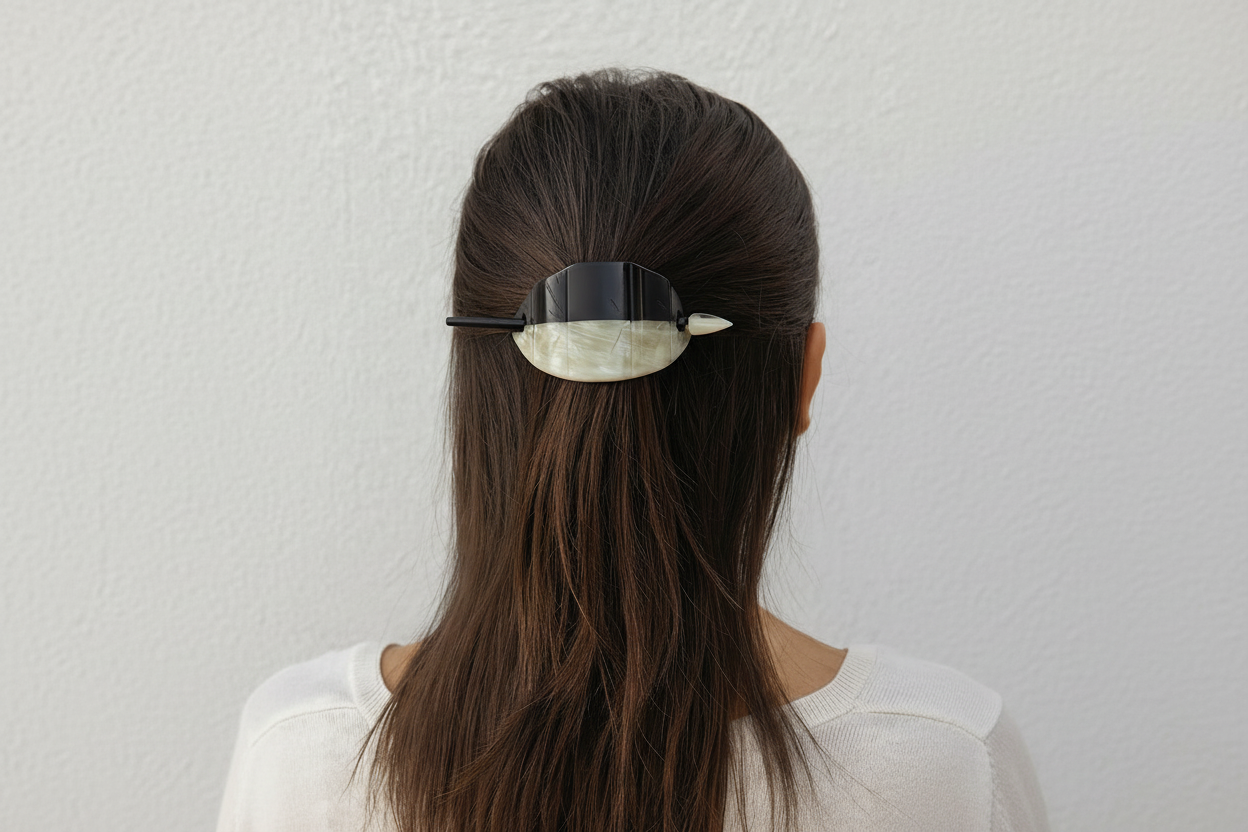 Person with a hair clip in their hair against a white background